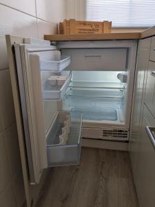 an empty refrigerator with its door open in a kitchen at Ruhiges Ferienhaus mit Sauna: Hellaberg III in Langenbach