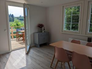 a dining room with a table and a balcony at Ruhiges Ferienhaus mit Sauna: Hellaberg III in Langenbach