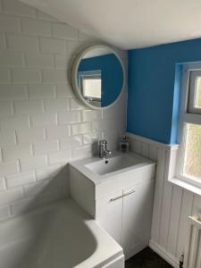 a bathroom with a white sink and a mirror at Coastal haven in Portstewart +16 photos
