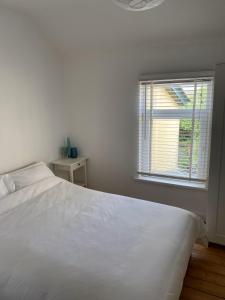 a bedroom with a white bed and a window at Coastal haven in Portstewart