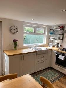 a kitchen with a sink and a clock on the wall at Coastal haven in Portstewart