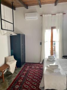 a room with a bed and a window and a rug at almond home in Livadia