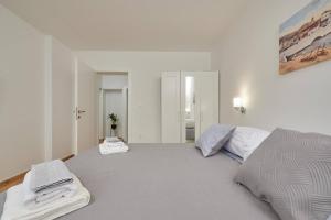 um quarto branco com uma cama com toalhas em Trau em Trogir