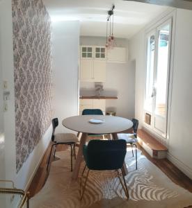 uma cozinha e sala de jantar com mesa e cadeiras em Flut'Alors - Maison charmante au centre-ville de Reims em Reims