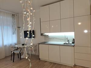 a kitchen with white cabinets and a table at sLOVEnian ART STORY in Ljubljana