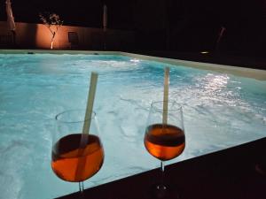 two glasses of wine in front of a swimming pool at Apartmani Gržinić in Rovinj