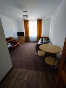 a living room with a table and chairs and a bedroom at Agroturystyka Osieki in Osieki
