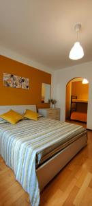1 dormitorio con 1 cama grande con almohadas amarillas en Chez Marie-Claire, en Montjovet