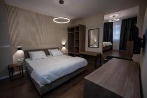 - une chambre avec un grand lit et une table dans l'établissement GRIFFON BAR FOOD APARTMENTS, à Struga