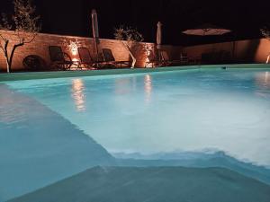 una gran piscina por la noche con sillas y sombrilla en Apartmani Gržinić en Rovinj