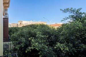 a group of trees with buildings in the background at Calypso Il Binario Elegance in Palermo