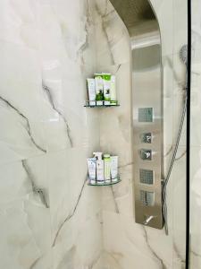 a bathroom with a shower with white marble walls at Casa Fratila in Holbav