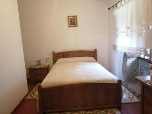 um quarto com uma cama de madeira e uma janela em Quinta Do Quetrofe na Guarda