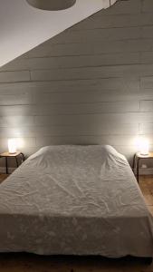 a bedroom with a white bed and two lamps at Grand gîte au cœur des Pyrénées - Ariège Mijanes in Mijanès