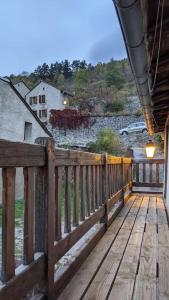 une terrasse couverte en bois avec une balustrade en bois sur une maison dans l'établissement Grand gîte au cœur des Pyrénées - Ariège Mijanes, à Mijanès