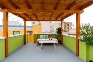 a roof deck with a pergola and a bench at La Casa Verde in Almería