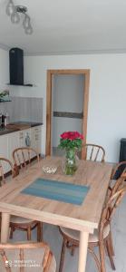 - une table à manger avec un vase de fleurs dans l'établissement Oaza Miłości, à Lipniki