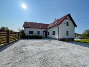 a white house with a fence and a gravel driveway at Chalupa Soběšice - kraj Šumavy in Soběšice