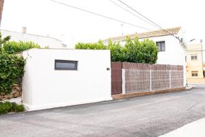 un garaje blanco con una puerta y una valla en Villa Carmensin en Deltebre