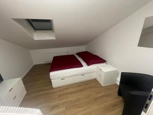 una piccola camera con un letto con una coperta rossa di Buxtehude*Wohnung*100qm*6 Schlafplätze*NEU* a Buxtehude