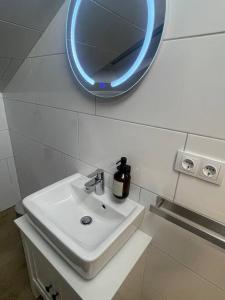 ein Bad mit einem Waschbecken und einem Wandspiegel in der Unterkunft Buxtehude*Wohnung*100qm*6 Schlafplätze*NEU* in Buxtehude