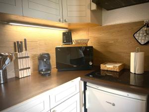 uma cozinha com um micro-ondas no balcão em Appartement 6 couchages, Tout confort, pieds des pistes em Montclar