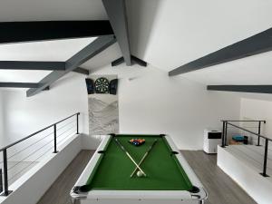 a green pool table in a room with stairs at Villa Pura Vida in Magescq
