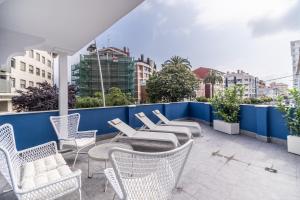 a group of chairs and tables on a balcony at VILLA MARTA - Apartamentos céntricos junto al mar in Castro-Urdiales