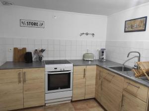 a kitchen with a white stove and a sink at Gîte à la campagne, proche Carcassonne in Alairac