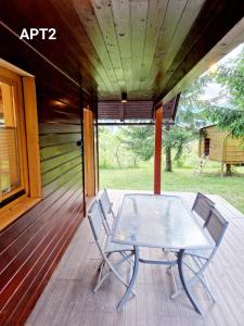d'une terrasse couverte avec une table et deux chaises. dans l'établissement Alpine Village Home, à Bohinj