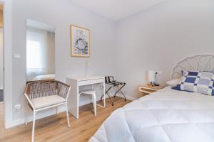 een witte slaapkamer met een bureau en een bed bij VILLA MARTA - Apartamentos céntricos junto al mar in Castro-Urdiales