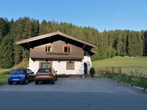 una casa con dos coches estacionados frente a ella en Haus Spertental, en Kirchberg in Tirol