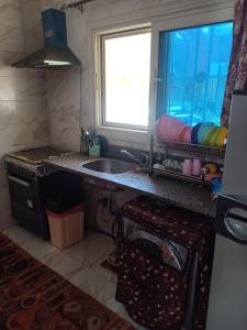 uma cozinha com um lavatório e uma janela em فيلا للايجار فى العين السخنة قرية لاجولى em Ain Sokhna