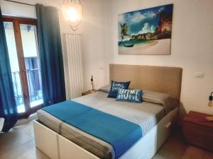 a bedroom with a large bed with blue pillows at Peri Peri House - Palermo Centro in Palermo