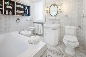 a white bathroom with a tub and a toilet at Villa Florinda in Bardolino +13 photos