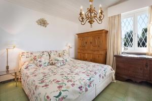 a bedroom with a bed and a dresser and a chandelier at Villa Florinda in Bardolino
