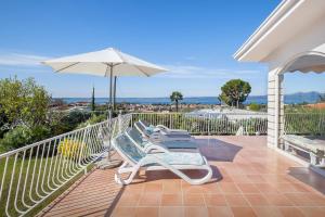 a patio with chairs and an umbrella on a balcony at Villa Florinda in Bardolino
