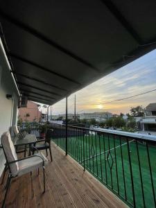 a deck with a table and chairs on a balcony at Boboli Holiday House Acharavi Corfu in Acharavi