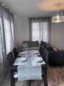 a living room with a table and a couch at Bel appartement en centre-ville in Le Blanc-Mesnil
