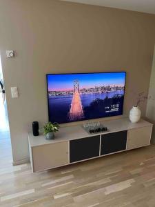 a flat screen tv sitting in a living room at Leilighet ved sjøkanten in Langevåg
