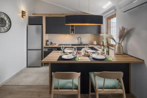 a kitchen with a large wooden island with two chairs at Villa Alena in Poreč