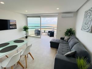 a living room with a couch and a table at Top Ocean View Apartment - amazing sunset - modern style - pool & 200m to beach in Portimão