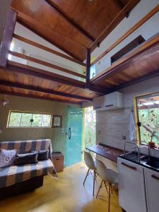 a room with a bed and a kitchen with a table at Chalé tribal in Alto Paraíso de Goiás