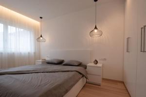 a bedroom with two pendant lights and a bed at Casa Pina Campo Tures in Campo Tures