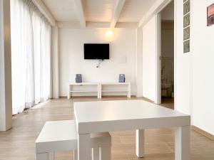 a living room with a white table and a tv at Loft Trabocco - Dimora dei Portici in Ortona