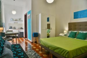 1 dormitorio con cama verde y comedor en Arcu de Chelu B&B, en Modolo