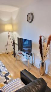 a living room with a couch and a tv at Balcony-view with Free and secured Parking in Manchester