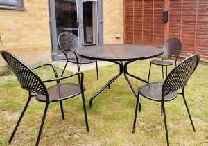 four chairs and a table with a table and four chairs at East London Townhouse sleeps 7 with 1 parking space in Goodmayes