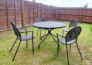 four chairs and a table in a yard at East London House near tube with parking in London