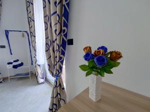 a vase filled with blue roses sitting on a table at Tirano Express Apartments in Tirano